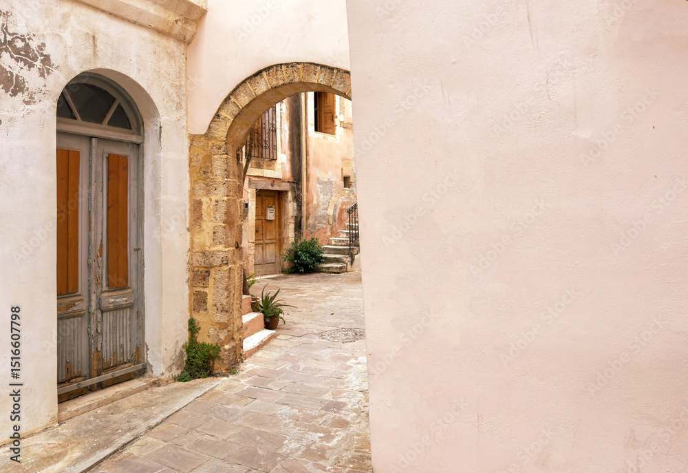 Obraz premium Chania old town architecture. Wooden door and stone arch pastel color walls. Crete island, Greece