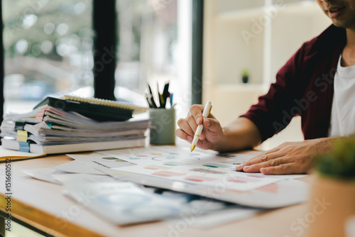 Portrait of a man working with documents using laptop in modern office. Preparing accounting analysis report, real estate investment information, finance and tax concept.