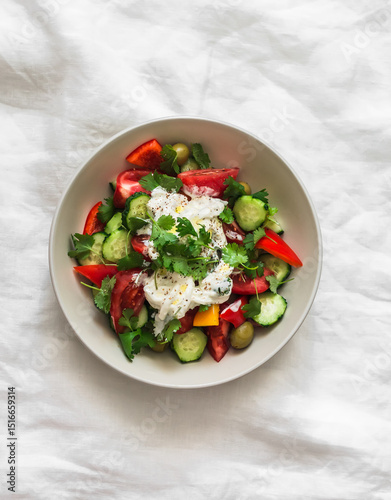 Fresh vegetable salad with stracciatella cheese and fresh cilantro on a light background, top view