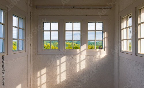 Window reflections and shadows in a public observation tower with a panoramic view over the forest landscape in Sauerland (Germany). Incident sunlight in the Danzturm in Iserlohn on spring evening. photo