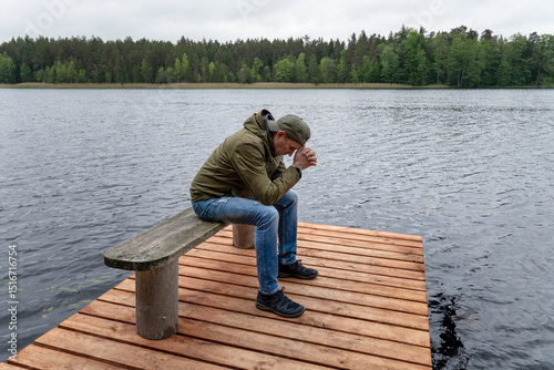 Tablou pe pânză Emotional Moment of Prayer on Wooden Pier – Man Seeking Peace by the Water