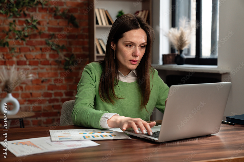 Focused Woman Working on Financial Calculations at Desk Focused Woman Working on Financial Calculations at Desk