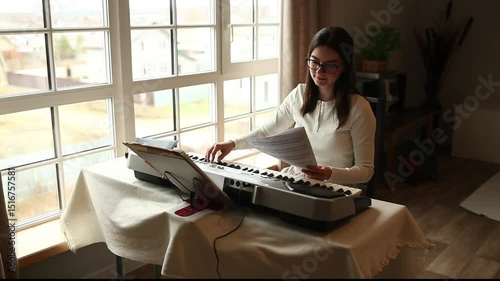 A female pianist studies a piece of music while looking at the score