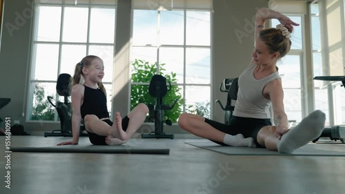 Mother and daughter are practicing gymnastics.	