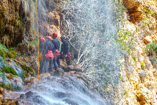 Canyoneering Adventure at a Scenic Waterfall in the Mountains During a Sunny Day