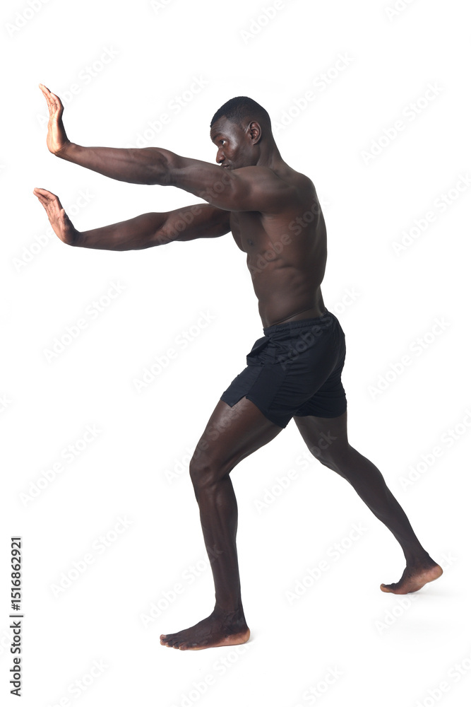 Obraz premium side view of a man wearing shorts pushing an imaginary wall.