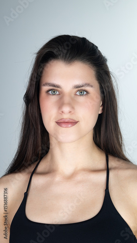 Portrait of confident young woman with long dark hair and brown eyes