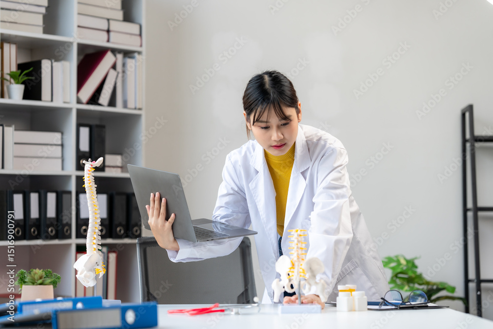 Fototapeta premium Doctor Explaining Spinal Anatomy with Laptop