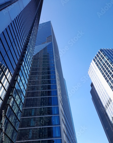 Towering, tall, blue skyscrapers reaching for the cloudless sky and reflecting it too. A beautiful background of generic London.