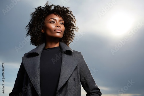 Confident businesswoman looking up at sky with hope and determination