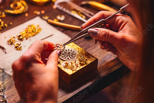 Artisan hands crafting fine gold jewelry using detailed tools in workshop