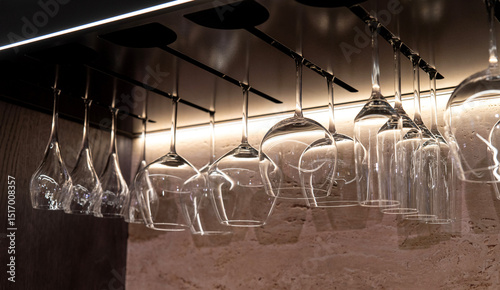 Hanging wine glasses under the shelf with warm accent lighting