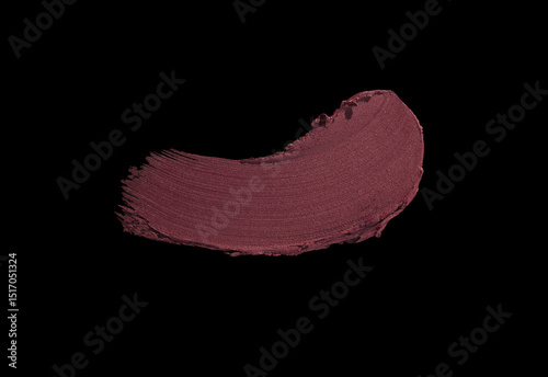 Cosmetic make-up beauty product. Matte dark burgundy claret maroon lipstick swatch isolated on black background