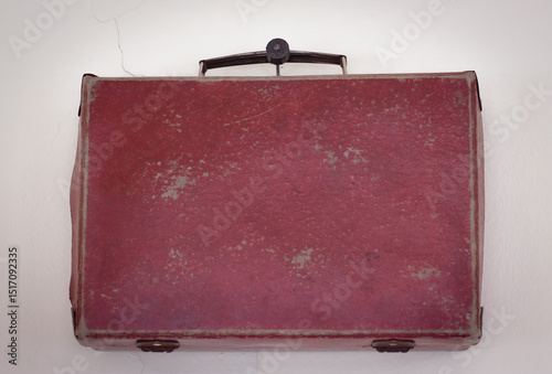 vintage red suitcase fixed to the wall