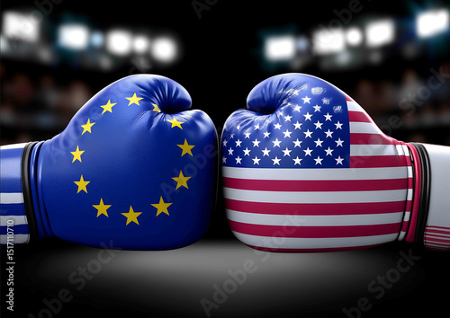 A pair of boxing gloves with the European Union and American flags facing each other in an arena The background is blurred to emphasize these unique items T
