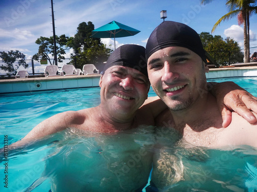 Selfie of dad and son hugging in the pool