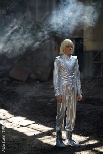 dressed in a futuristic silver costume in a lit