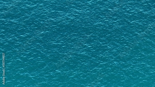 A bird’s-eye view highlights the turquoise ocean, with gentle waves flowing across the surface, forming a soothing, patterned texture that captures the peacefulness of the tropical sea.
