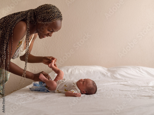 Woman talking to baby while changing diaper
