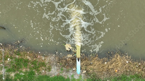 Water flows from a pipe into an agricultural waterway, demonstrating irrigation practices essential for crop growth and efficient water management in farming. photo