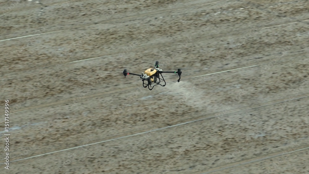 Fototapeta premium A modern agricultural drone sprays pesticides with precision over rice fields, enhancing efficiency, sustainability, and crop health through innovative automated farming technology. 