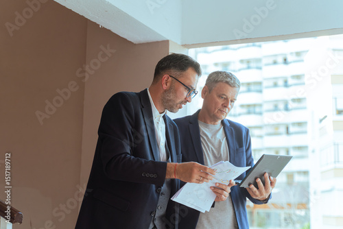 A two man businessman Reviewing Documents and Digital Tablet in Modern Office