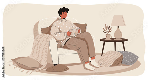 Cozy young man knitting while sitting on a sofa in a warm room  
