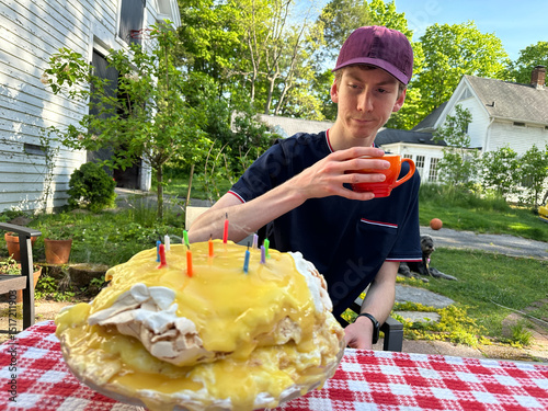 young man  looking at a failed birthday cake 