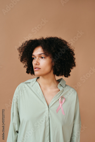 Woman in Soft Green Shirt With Pink Ribbon Accent
