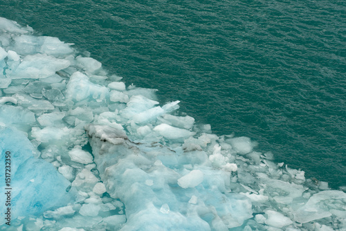 melting glacier ice floating in turquoise water. photo