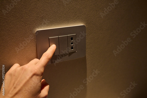 Hand pressing a light switch button  photo