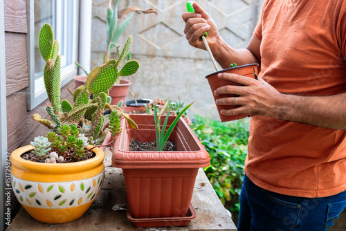 Latin man handling plant pots in the garden at home