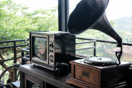 Perfect illustration for retro background style, with old tv, retro camera, gramophone on a desk beside old bycicle.