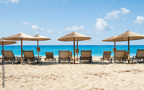 Empty beach chairs and umbrellas on a tropical beach