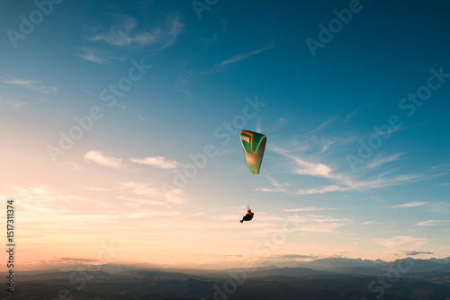 Paraglider freedom flying on sunset sky 