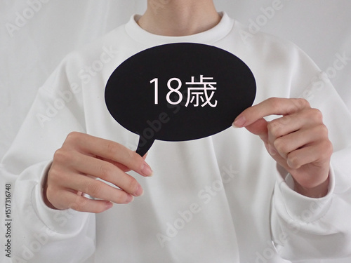 若い男性が持っている吹き出しに18歳の文字
