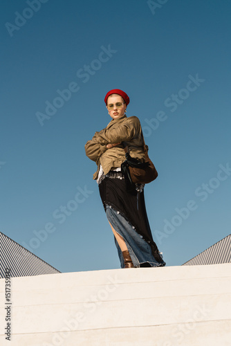 Confident person in red sailor-style hat standing on white steps
