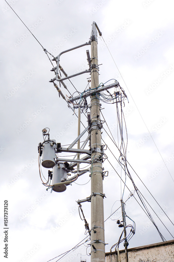 Electrical Pole with Sky Background: A detailed view of an electrical pole, showcasing the intricate network of transformers and wires against a backdrop of a cloudy sky. Electrical Pole with Sky Background: A detailed view of an electrical pole, showcasing the intricate network of transformers and wires against a backdrop of a cloudy sky.