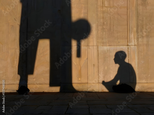 Shadow of Guidance: A poignant silhouette of a figure cast on a textured wall, observing a child sitting cross-legged, evoking a sense of mentorship and protection.