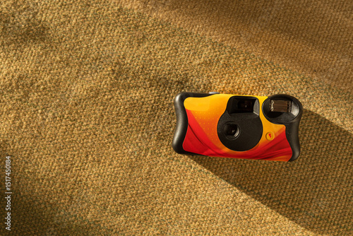 Colorful disposable film camera on green fabric