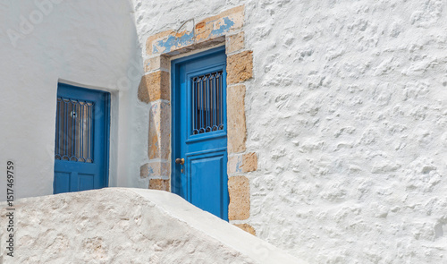 white facade wih blue doors of a traditional greek house