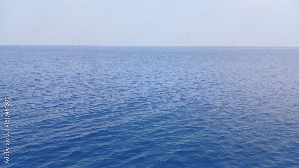 Obraz premium Calm and expansive view of the ocean under clear blue sky on a sunny day.