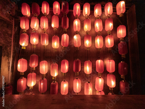 Warm red lanterns decorating rustic wooden wall