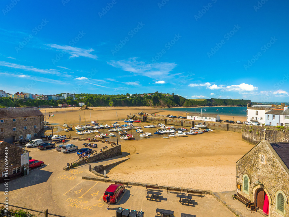 Obraz premium Tenby, Wales, United Kingdom - 26th June 2024 - Tenby Harbour with boats grounded by low tide