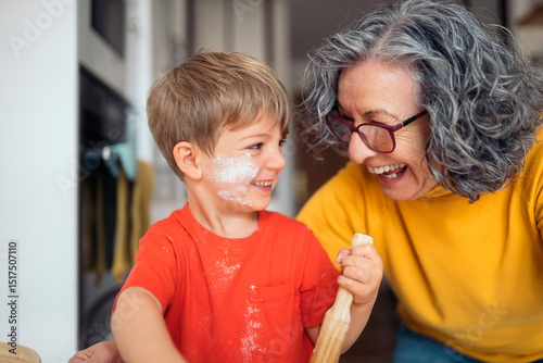 Grandmother and grandson baking and having fun in the kitchen