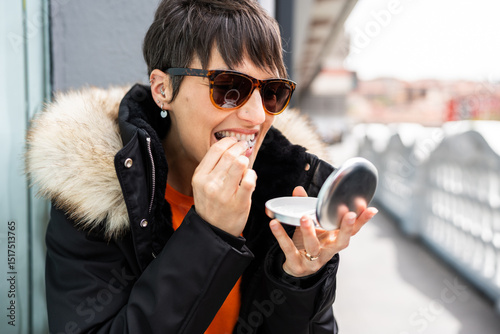 Woman putting invisible braces aligner in her mouth photo