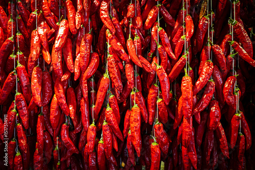 Great view of thousands of threaded chili peppers hanging from a wall at the Mercado dos Lavradores (farmer's market) in Funchal, Madeira, Portugal photo