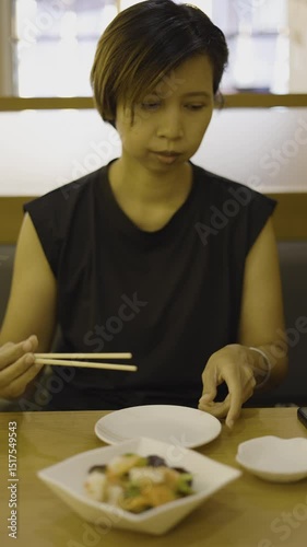 Woman Is Using Chopsticks To Pick Up Food, Video footage for documentary and cinematic in food scene.