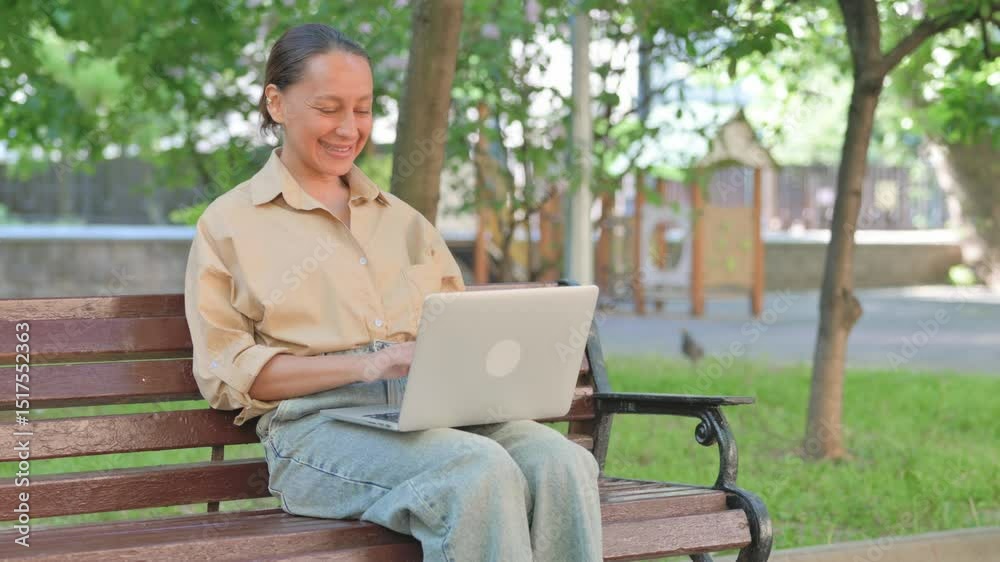 Cheerful Young Woman with Laptop Enjoying Win on Park Bench Cheerful Young Woman with Laptop Enjoying Win on Park Bench