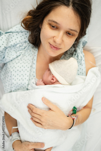 Newborn cradled by mother in hospital setting photo
